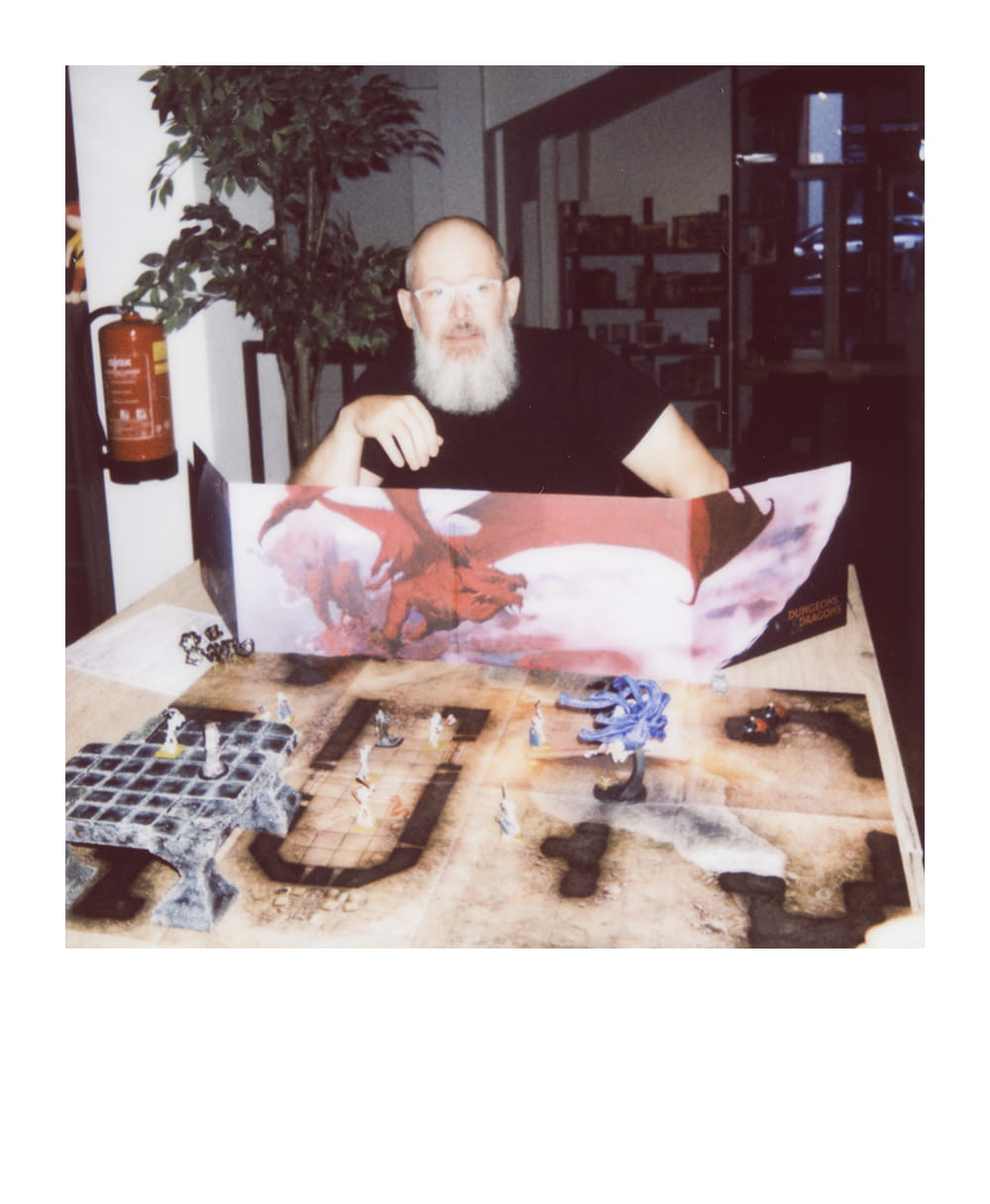 Game Master sits behind a Dungeons & Dragons screen with dungeon terrain and fantasy miniatures.