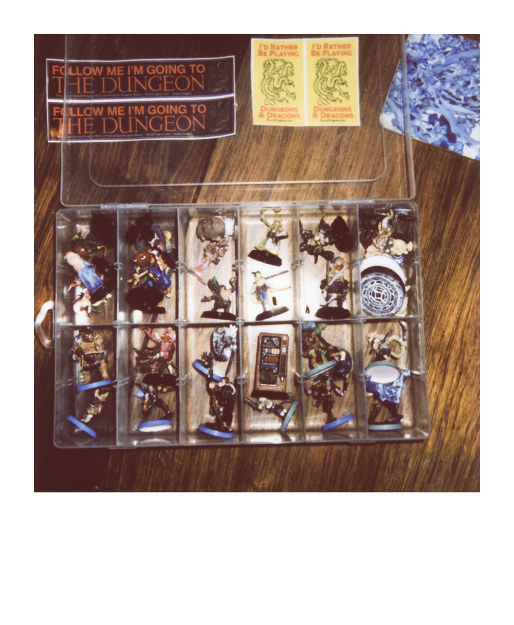 Organizer case filled with painted D&D miniatures and tabletop gaming stickers.